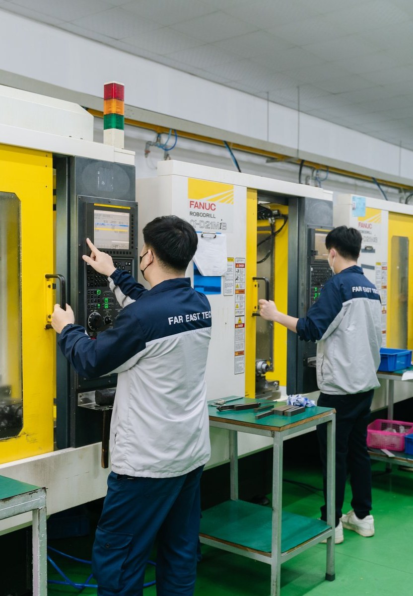 Far East Tech shop floor — engineers operating FANUC RoboDrill machines
